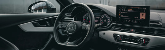 Audi car interior with steering wheel and dashboard showing Apple Carplay Interface