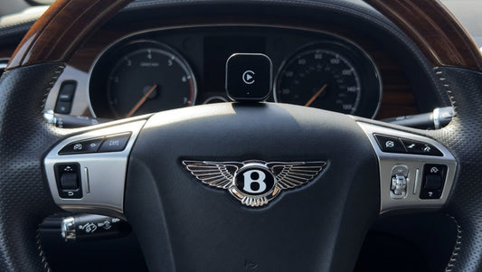Wireless Apple CarPlay adapter placed inside a Bentley interior. Plug-and-play infotainment upgrade for compatible Bentley models with factory wired CarPlay support.