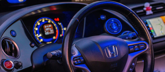 Car dashboard screen in a Honda showing the wireless Apple CarPlay interface with navigation maps and music widgets connected via wireless carplay adapter.