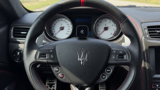Wireless Apple CarPlay adapter placed inside a Maserati cabin. Plug-and-play infotainment upgrade for compatible Maserati models with factory wired CarPlay support.