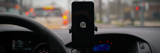 Smartphone mounted on a car dashboard with no cellular network sign on the screen
